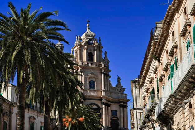 Italien. Sizilien, Ragusa Ibla, Palmen, alte Barockgebäude und die barocke Fassade der St.-Georgs-Kathedrale