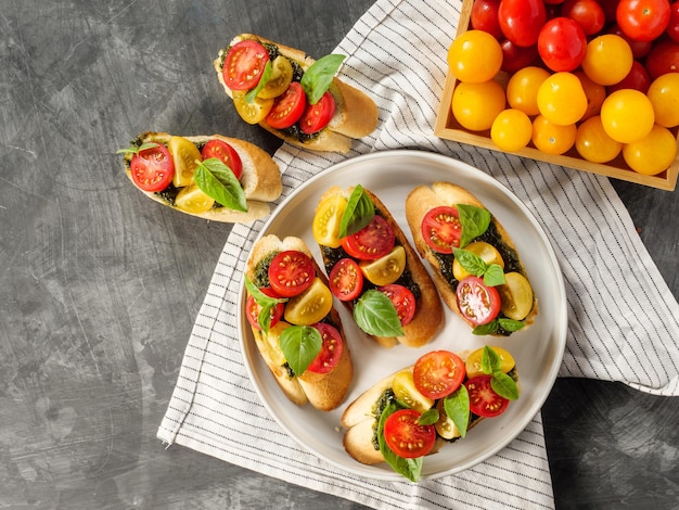 Italienische Antipasti-Bruschetta mit Tomatenbasilikum und Pesto auf einem grauen Tisch Kopierbereich