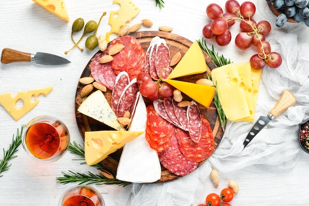 Foto italienische antipasti-wein-snacks set käsesorte salami und trauben auf weißem holzhintergrund italienische küche draufsicht freier platz für ihren text