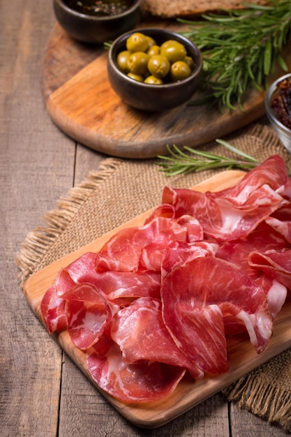 Italienische Coppa-, Capocollo-, Capicollo- oder Rohschinkenscheiben mit Rosmarin. Rohkost.