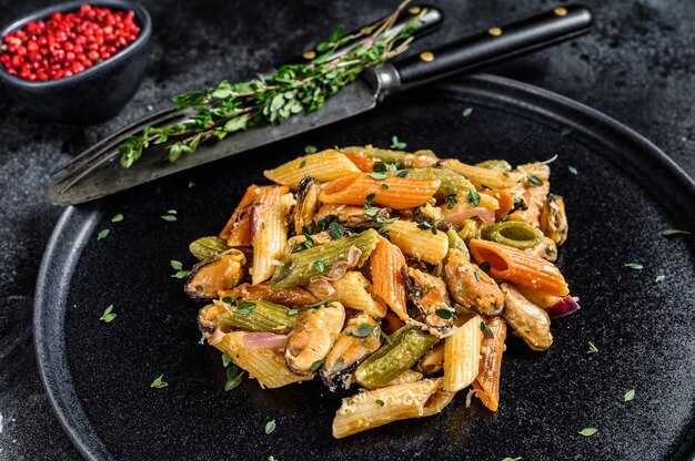 Italienische Farbe Penne Nudeln mit Muscheln auf einem Teller