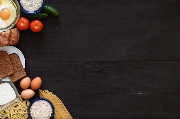 Italienische gesunde Nahrungsmitteltabelle, Spaghetti-Gemüse auf schwarzem Holzschreibtisch, Draufsicht