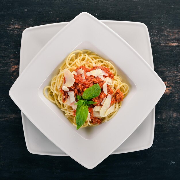 Italienische Küche Pasta mit Tomaten und Parmesan-Käse Auf einem hölzernen Hintergrund Ansicht von oben Kopieren Sie Platz