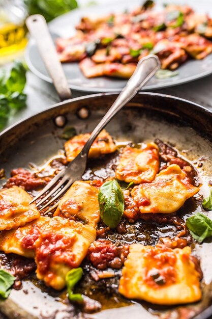 Foto italienische oder mediterrane pasta ravioli aus tomatensauce und basilikum