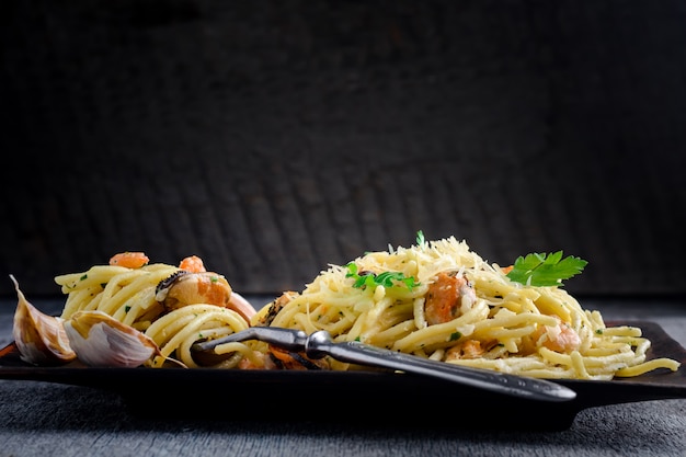 Italienische Pasta in einer cremigen Sauce mit Meeresfrüchten, Garnelen und Muscheln auf einem Teller