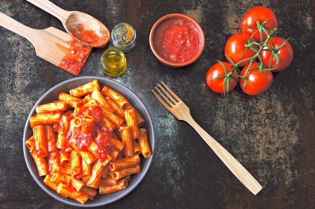 Italienische Pasta in einer Schüssel mit frischer Tomatensauce. Vegane Schüssel mit Nudeln in Tomatensauce.