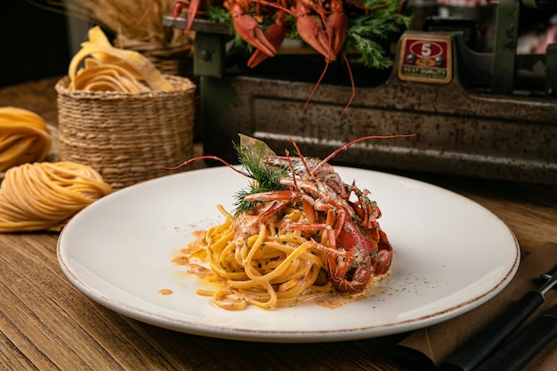 Italienische Pasta mit gekochten Flusskrebsen und Sauce auf einem hölzernen Bauerntisch