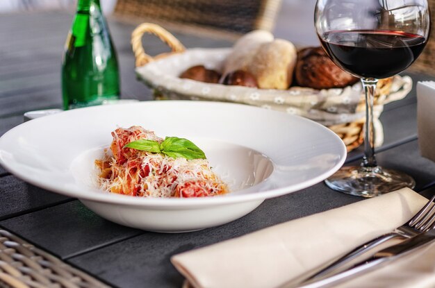 Italienische Pasta mit Tomaten, Käse und einem Zweig Basilikum