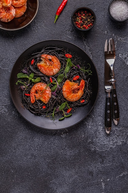 Italienische Pasta schwarze Spaghetti mit Garnelen und Microgreens