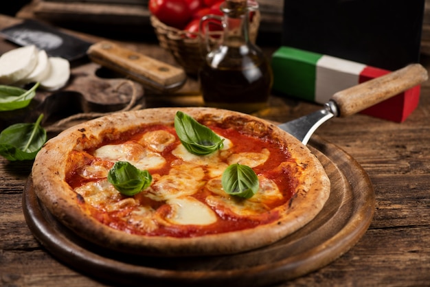 Italienische Pizza Margherita auf einem rustikalen Holztisch. Nahaufnahme