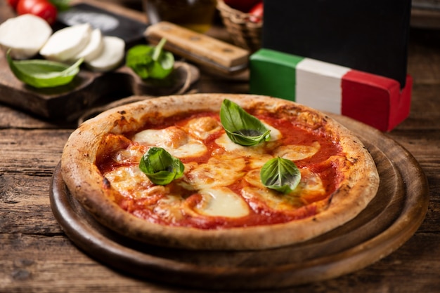 Italienische Pizza Margherita auf einem rustikalen Holztisch. Nahaufnahme