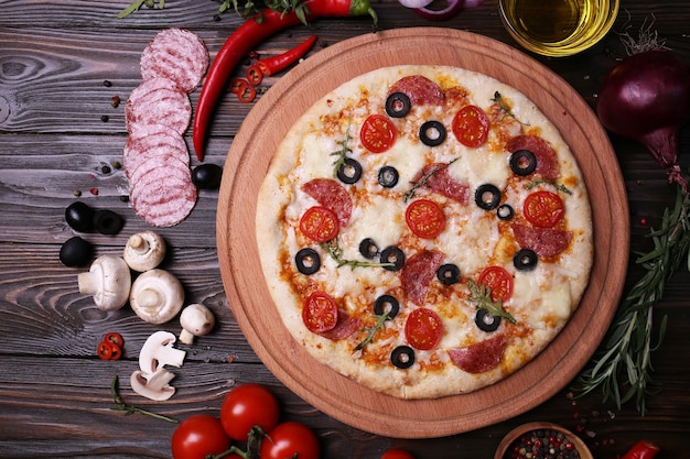 Italienische Pizza mit den besten Produkten mit Tomaten, Mozzarella, Champignons und Olivensalami