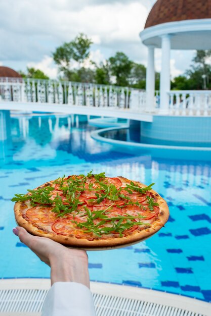 Italienische Pizza mit Kräutern auf einem Holztisch