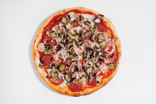 Italienische Pizza mit Salami, Champignons, Zwiebeln und eingelegten Gurken