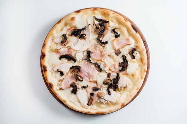 Italienische Pizza mit Schinken, Hähnchen und Pilzen