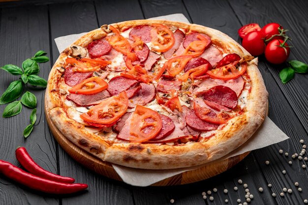 Italienische Pizza mit Schinkenwurst, Pilzen, Tomaten und Zwiebeln