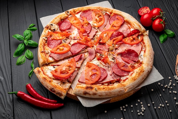 Italienische Pizza mit Schinkenwurst, Pilzen, Tomaten und Zwiebeln