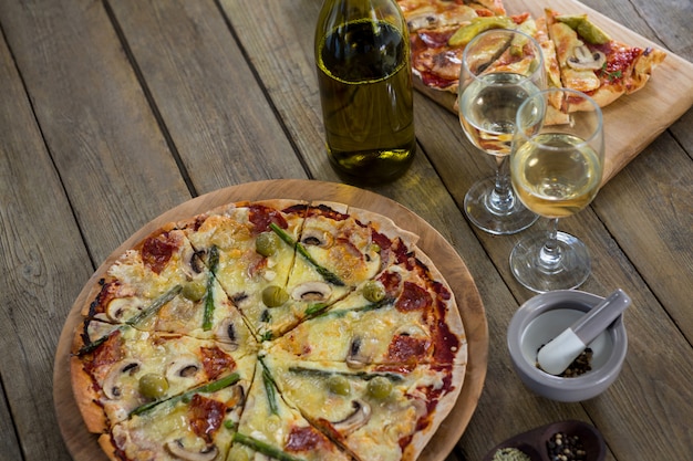 Italienische Pizza mit Weingläsern und Zutaten