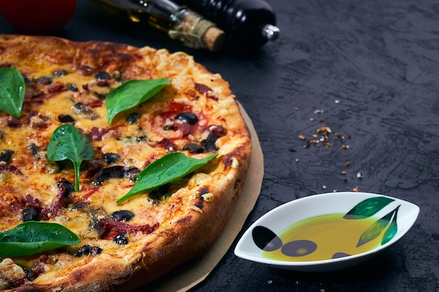 Italienische Pizza und Kochzutaten auf dunklem Hintergrund Tomaten Oliven Öl Kräuter und Gewürze