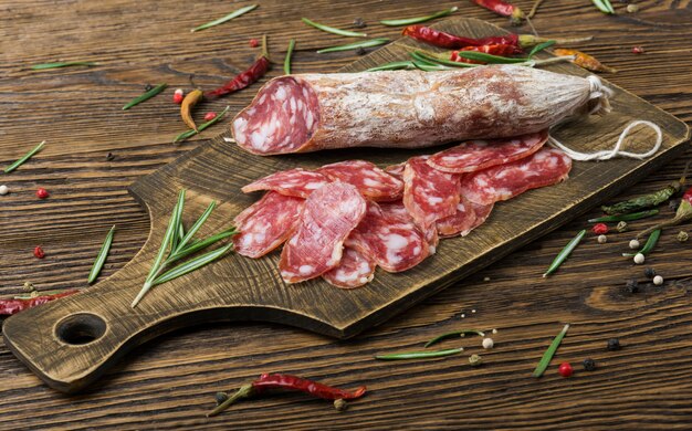 Italienische Salami mit Pfeffer und Rosmarin auf einem Holzbrett