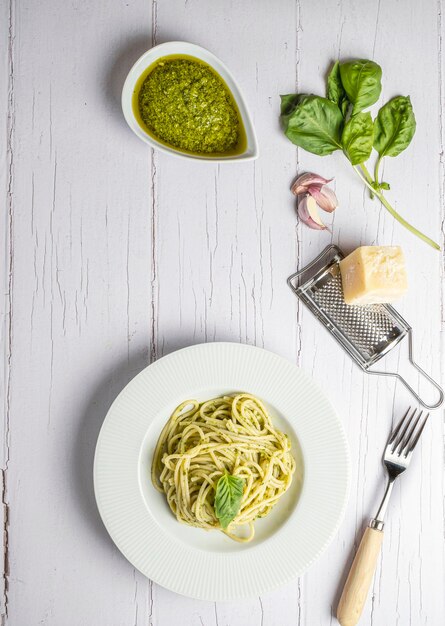 Italienische Spaghetti mit frischer hausgemachter Pesto-Sauce, die auf einem weißen Holzbrett gegessen werden