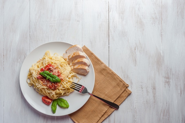 Italienische Spaghetti-Nudeln mit Sauce und Hühnchen, Käse-Parmesan und Basilikum