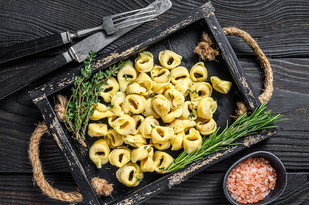 Italienische traditionelle Tortellini-Nudeln mit Spinat in einem Holztablett