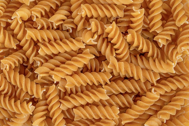 Italienische Vollkorn-Bio-Nudeln Fusilli Hintergrund Draufsicht aus nächster Nähe