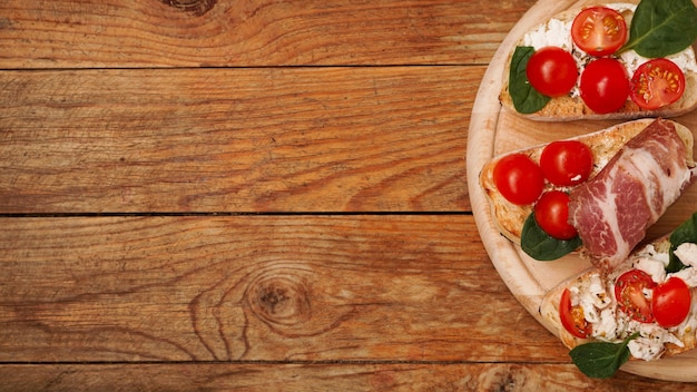 Italienische Vorspeise Bruschetta auf einem Holzbrett auf einer hölzernen rustikalen Oberfläche