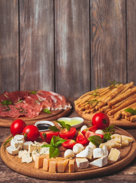 Italienische Vorspeise - verschiedene Arten von Schinken, Käse und Grissini mit Kopienraum an der Wand