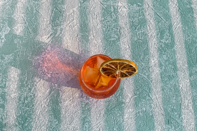 Italienischer Aperol Spritz Alkohol Cocktail mit Eiswürfeln und getrockneter Orangenscheibe