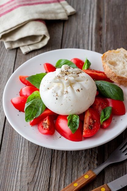 Italienischer Burrata-Käse mit Tomaten und Basilikum. Salat. Gesundes Essen. Vegetarisches Essen.