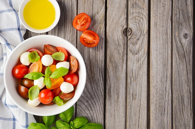 Italienischer Caprese-Salat mit Kirschtomaten, kleinem Mozzarella und frischem Basilikum.