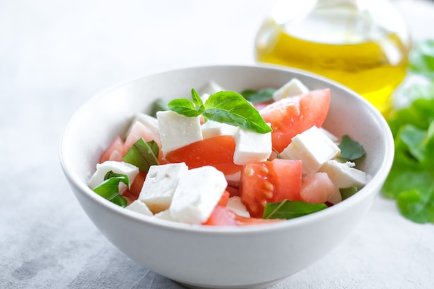 Italienischer Caprese-Salat mit Tomatenscheiben Mozzarella-Basilikum-Olivenöl auf hellem Hintergrund