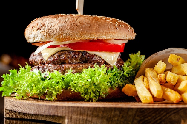 Italienischer Doppelkönigburger mit Pommes Frites auf einem Holzbrett