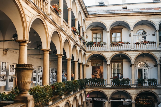 Italienischer Innenhof in der Altstadt von Lemberg mit Touristen, die ihn betrachten.