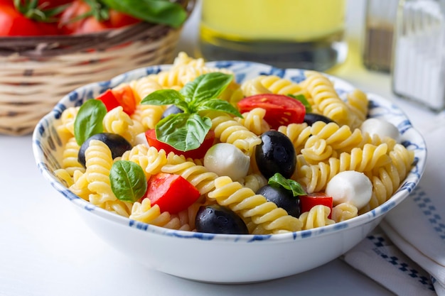 Italienischer kalter Nudelsalat oder Pasta fredda alla caprese. Direkt darüber. Fusilli, Tomaten, Mozzarella, Oliven, Rucola. Türkischer Name; burgu makarna salatasi