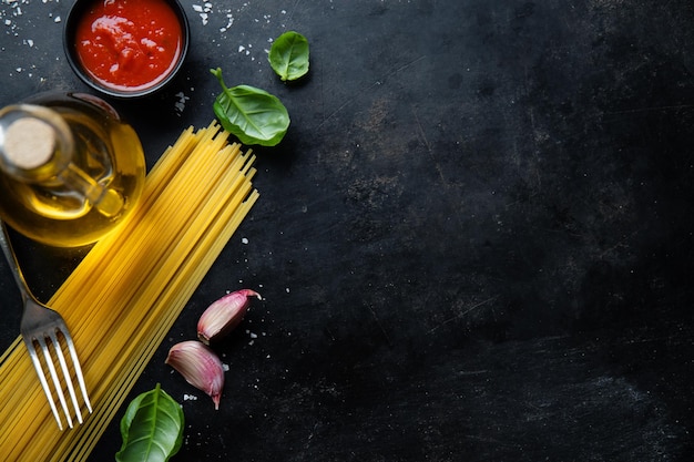 Italienischer Lebensmittelhintergrund mit Spaghettigewürzen und -soße Ansicht oben