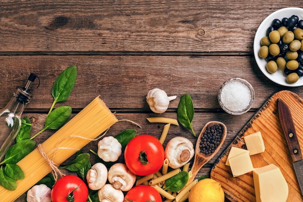 Italienischer Lebensmittelhintergrund mit Teigwarengewürzen und Draufsichtkopienraum des Gemüses
