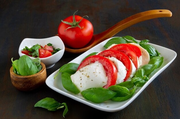 Italienischer Salat Antipasti namens Caprese mit Büffelmozzarella, Tomate und Basilikum mit Olivenöl