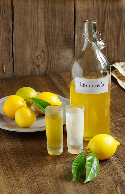 Italienisches alkoholisches getränk, limoncello auf holztisch