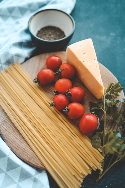 Italienisches Essen, das Tomatenbasilikumteigwaren und -käse auf Draufsichtkopienraum des Steinhintergrundes kocht