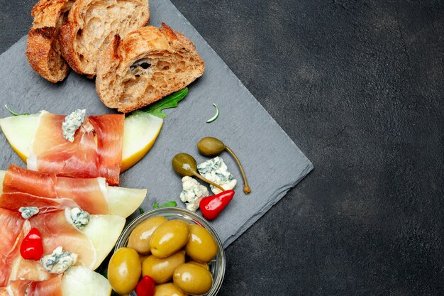 Italienisches Essen mit Melone und Schinken auf Steinbrett