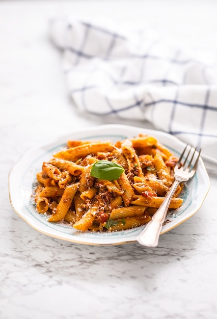 Italienisches Essen und Pasta Pene mit Bolognese-Sauce auf dem Teller.