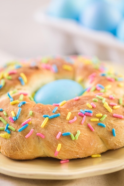 Italienisches Osterbrot mit blau gefärbtem Ei und Streuseln.