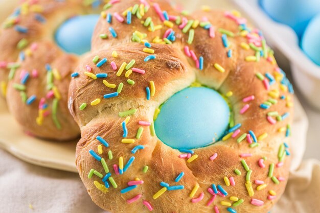 Italienisches Osterbrot mit blau gefärbtem Ei und Streuseln.