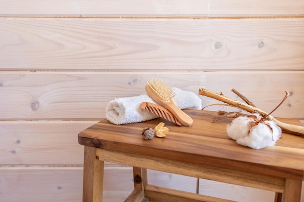 Itens de spa enrolados pentes de massagem de toalha em fundo de madeira Produtos ecológicos de beleza orgânica Conceito spa cosméticos Produto de beleza orgânico natural