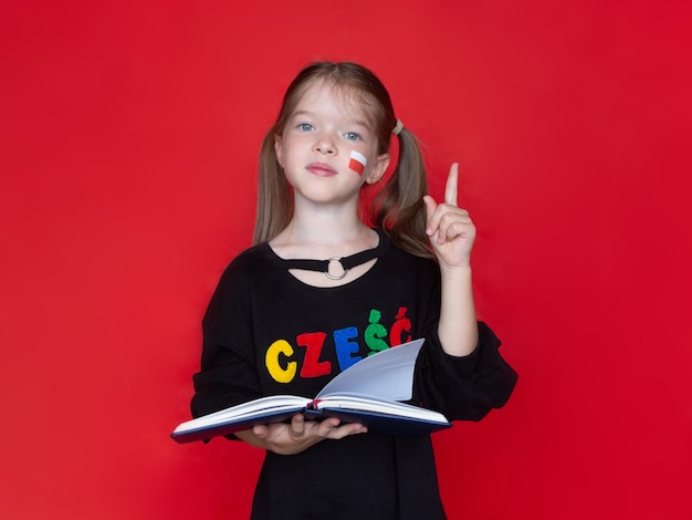 ittle girl tengo un cuaderno o libro en la mano, concepto de publicidad para aprender polaco