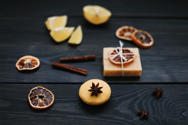 Jabón artesanal natural con rodajas secas de naranjas y canela sobre una superficie oscura