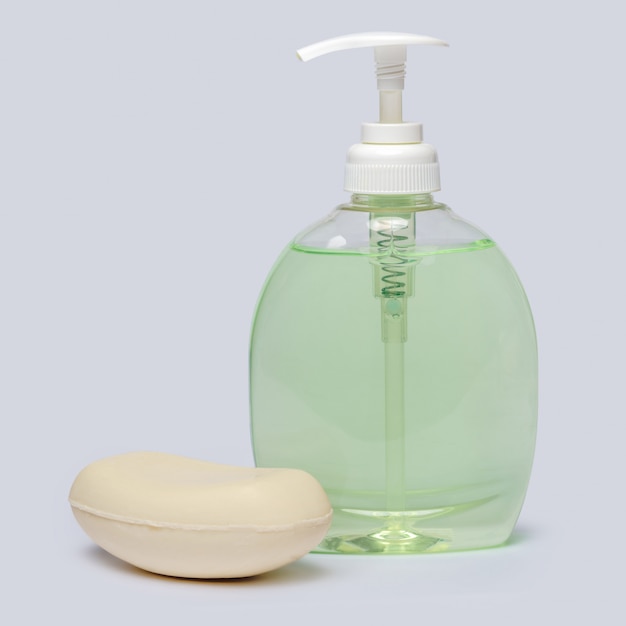 Foto jabón y botella de jabón líquido sobre fondo gris claro con trazado de recorte
